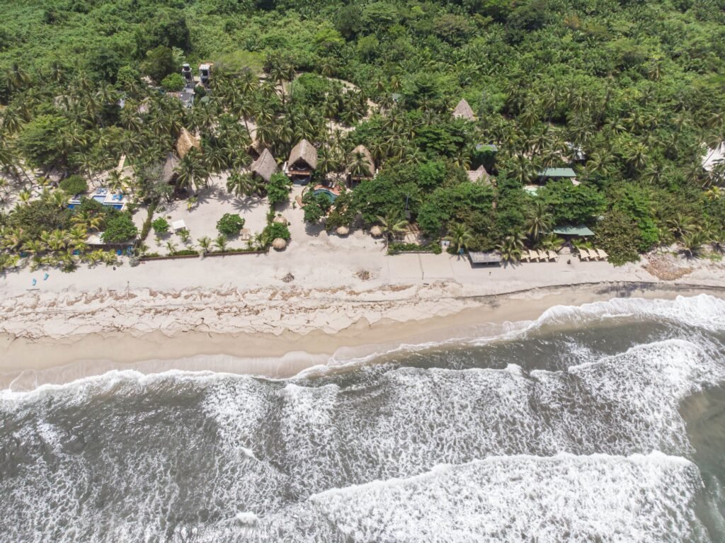Playa de arena y olas del mar Caribe frente a Casa Iwana vistas desde el aire