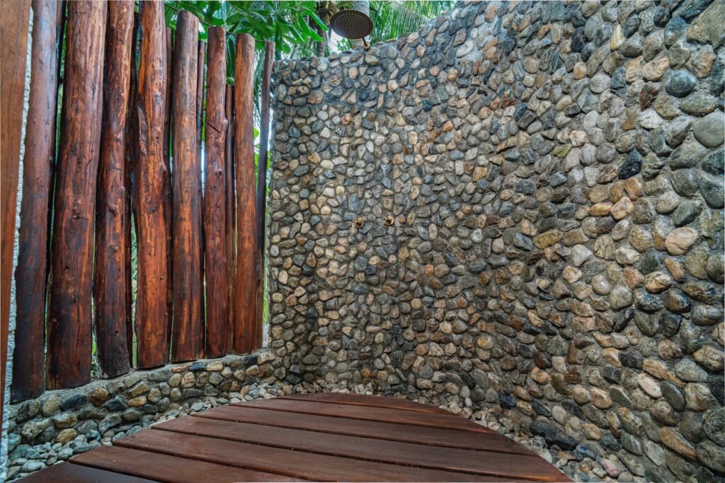 Ducha exterior de piedra de la suite del primer nivel de Casa Iwana