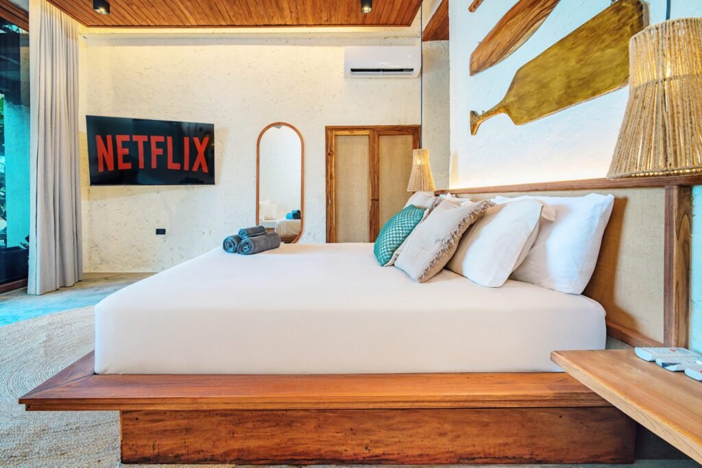 Suite del primer nivel con Smart TV y remos tallados sobre el cabecero