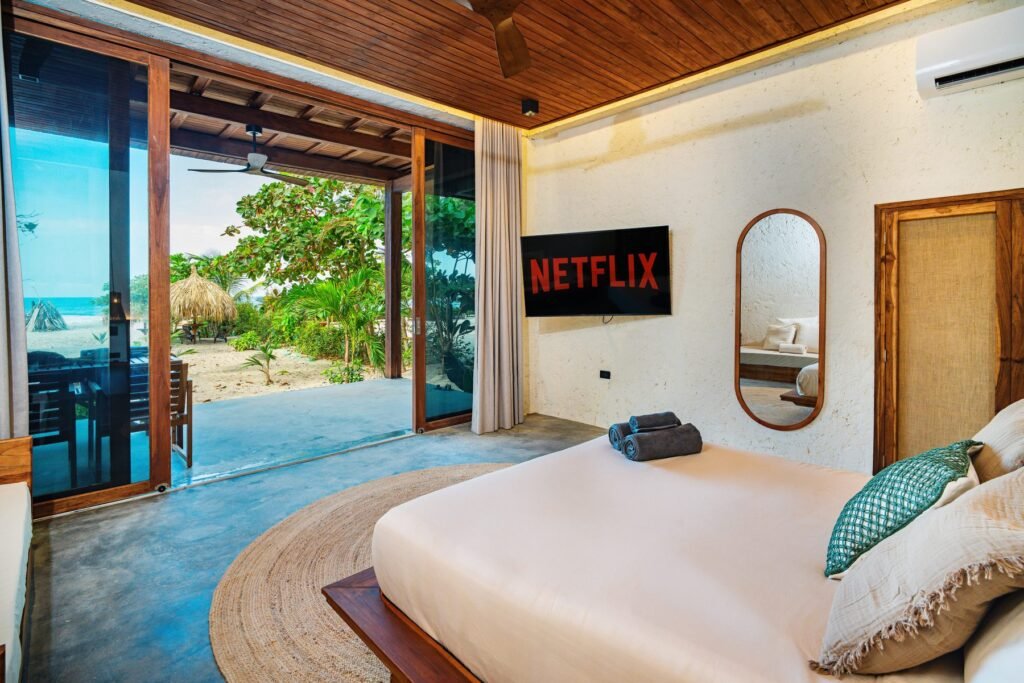 Cama de la suite del primer nivel con la puerta abierta al mar Caribe