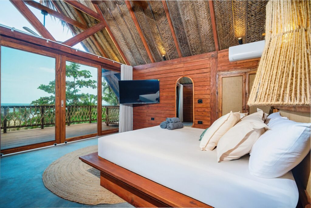 Cama de la suite del segundo nivel bajo el techo de palma