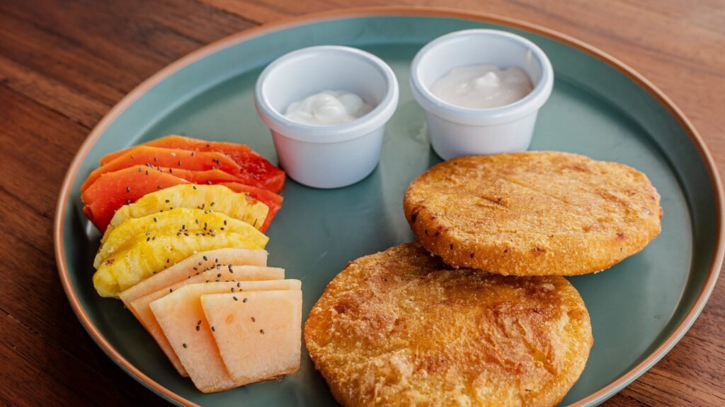Amanecer Costeño: arepas de huevo crujientes con queso y fruta fresca