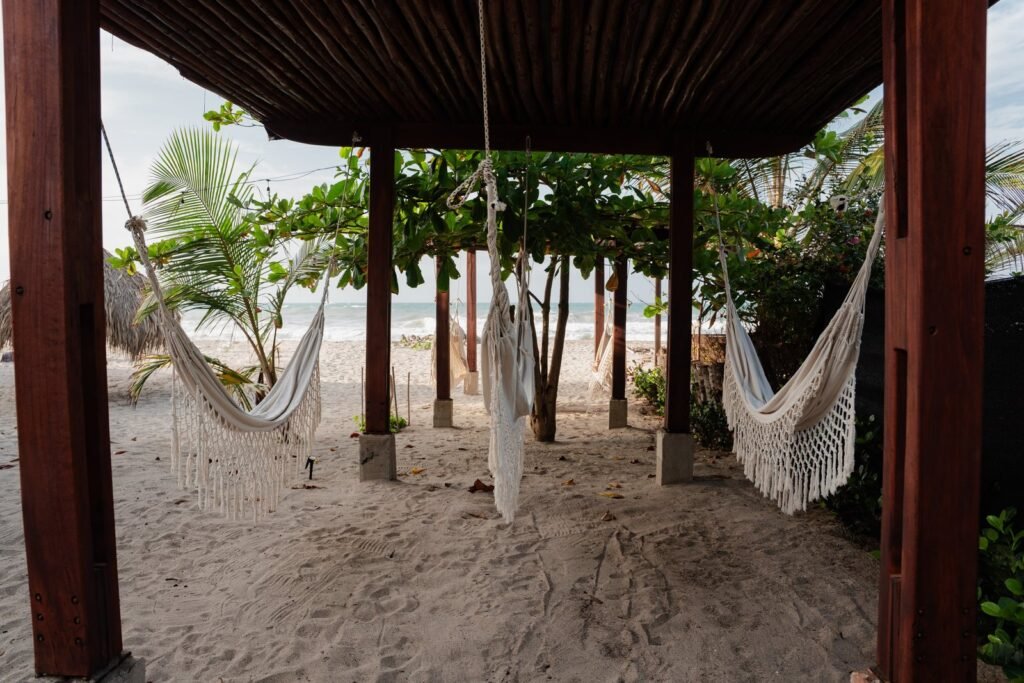 Zona de hamacas de Casa Iwana bajo la pérgola, sobre la arena y frente al mar