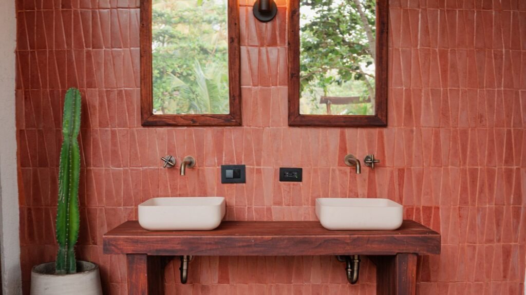 Doble lavamanos de diseño del baño exterior de Casa Iwana, sobre pared de terracota